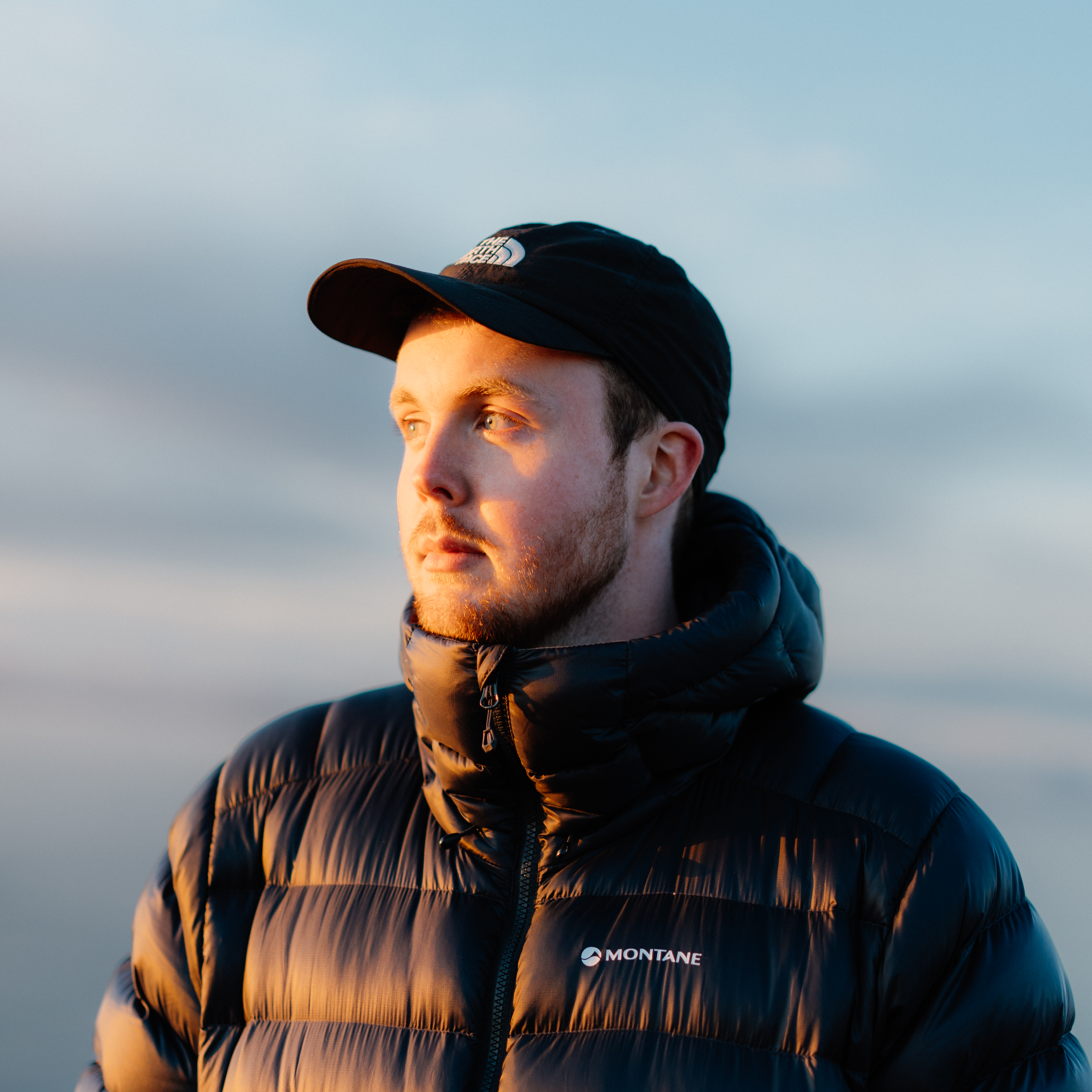Jacob Murray wearing a black baseball cap and puffer jacket.